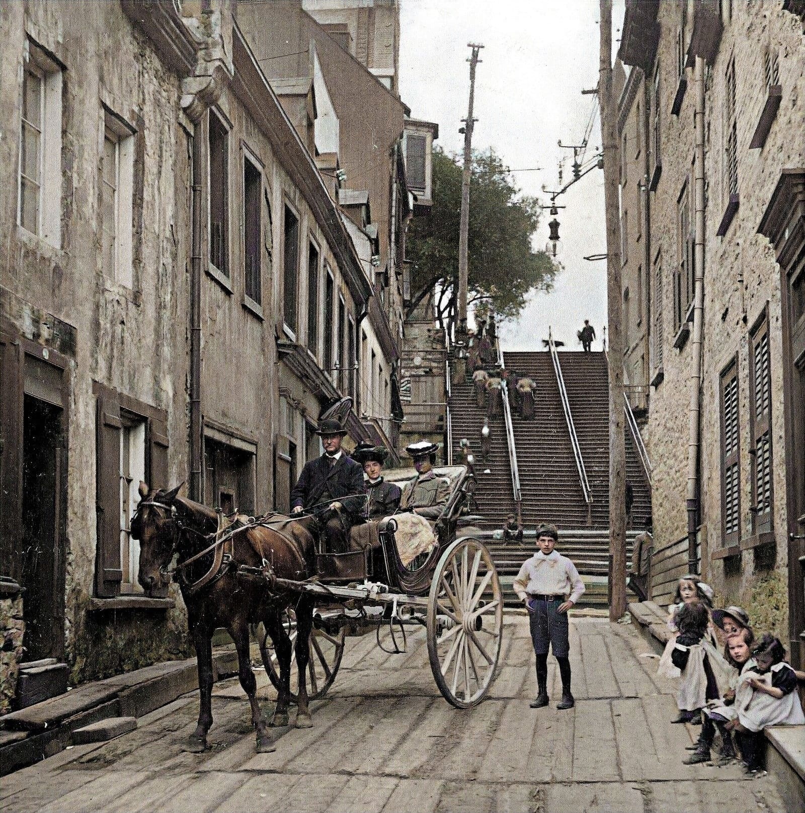 L’escalier Casse-Cou vers 1903, calèche et enfants au pied des marches (photographie colorisée)